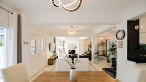 A modern hotel lobby with a wooden reception desk, white walls, and a large clock. - Beach Blue Villa , Luxury 3-Bedroom Villa with Sea View (Korinthos)