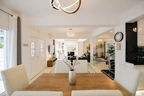 A modern hotel lobby with a wooden reception desk, white walls, and a large clock. - Beach Blue Villa , Luxury 3-Bedroom Villa with Sea View (Korinthos)