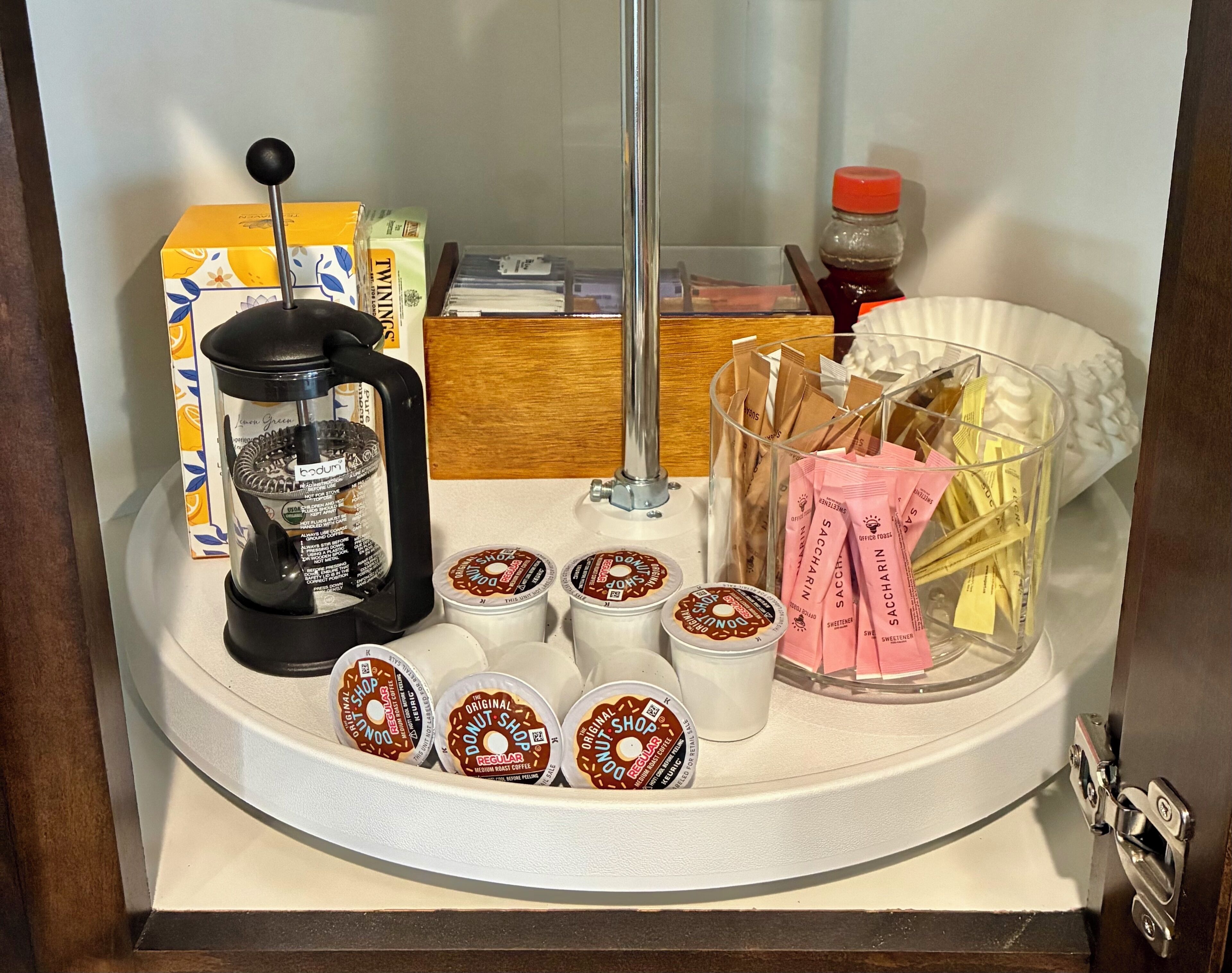 Une machine à café, une boîte, une bouteille et des dosettes de café sur un plan de travail.