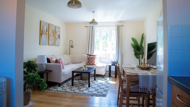 Una sala de estar con sofá, mesa de centro y comedor con mesa y sillas.