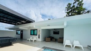 A modern outdoor pool area with a built-in pool, white lounge chairs, and a covered seating area. - Luxury Casa Kiarita • House on the Hill (San Juan)