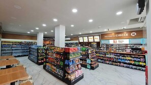 A grocery store interior with shelves stocked with various products, a coffee section, and a sign welcoming customers to Circle K. - Sovrano Hotel Batam (Batam)