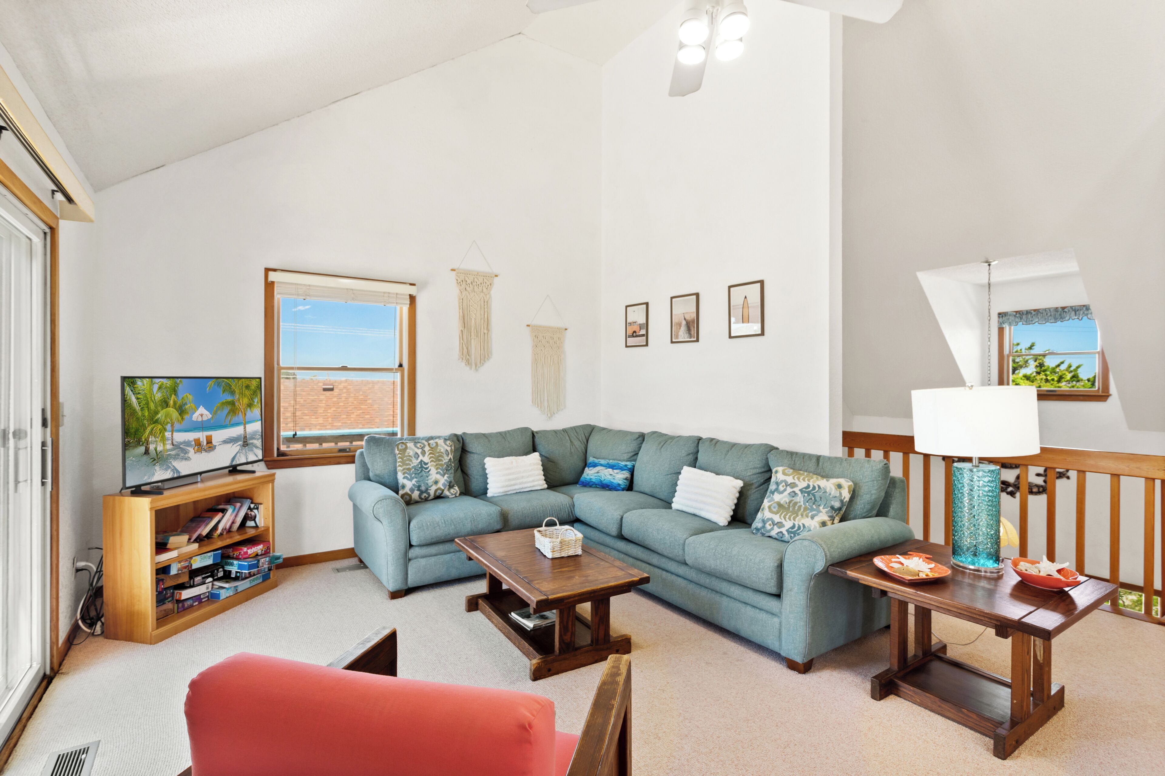 A living room with a sectional sofa, a television, a wooden coffee table, and a lamp.