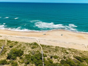 An aerial view of a beach with a clear path leading to the shore, surrounded by sparse vegetation. - White Dune: Dogs Allowed, Basketball Goal, Easy Beach Access (Avon)