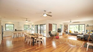 Un salón amplio con una mesa de comedor, sofás y una televisión.