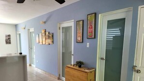 A hallway with a reception desk, a wooden cabinet, and a door with frosted glass.