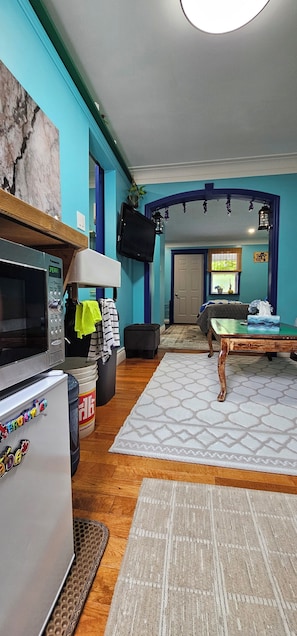 Ein Wohnzimmer mit Fernseher, Mikrowelle, Kühlschrank und Kamin.