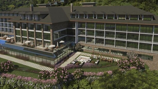 A modern hotel with a large glass facade, a rooftop pool, and a landscaped garden.