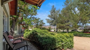 A patio with outdoor furniture, a well-maintained hedge, and a view of a residential area with trees and a distant mountain. - Comfortable cabin for two with full kitchen and a freshly updated bathroom, near Topaz Lake (Coleville)