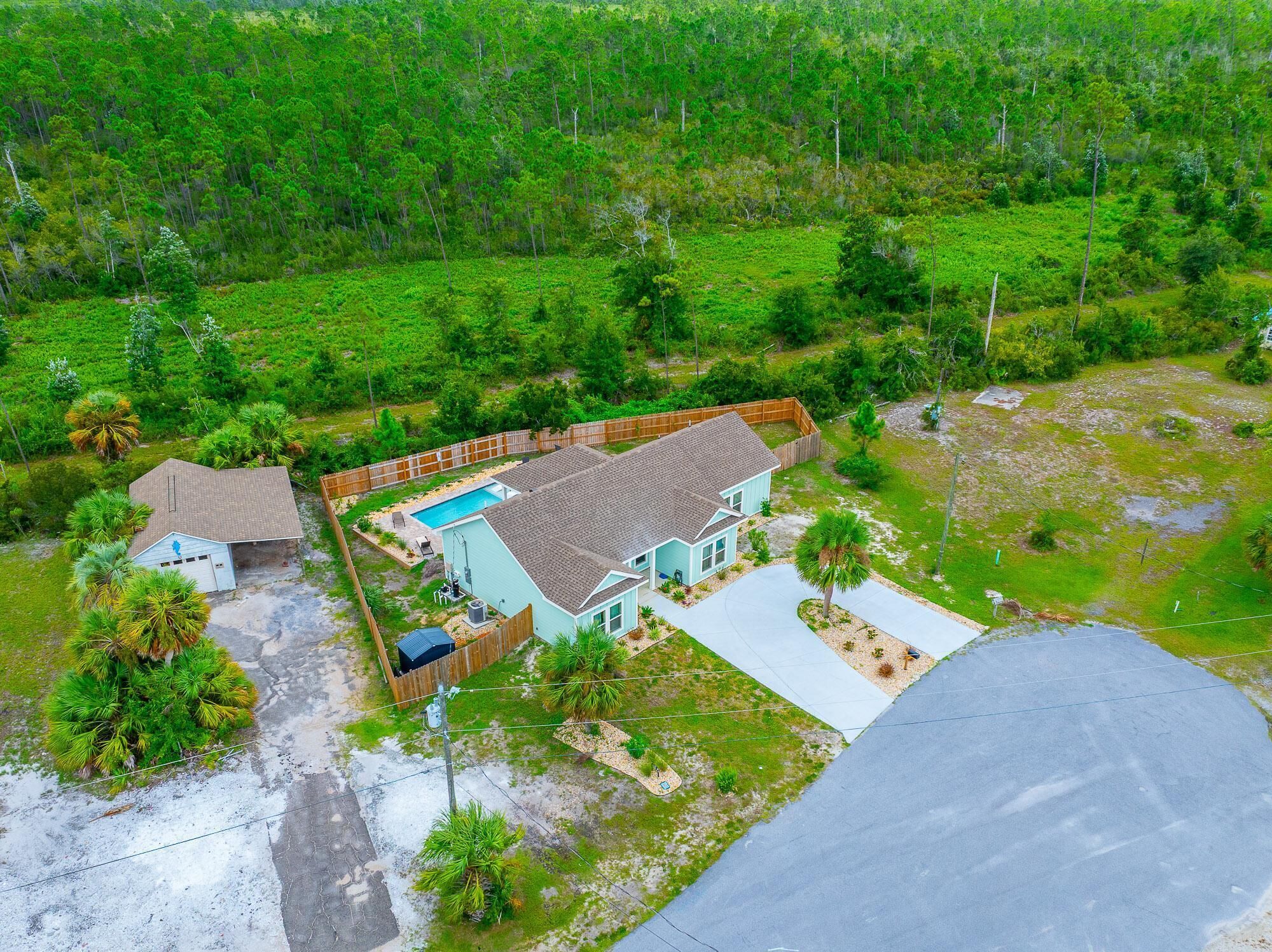 Propiedad residencial con piscina, garaje y patio cercado.