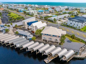 A coastal residential area with a prominent building featuring a blue roof and a dock with boats. - Living the Dream (Port St. Joe)