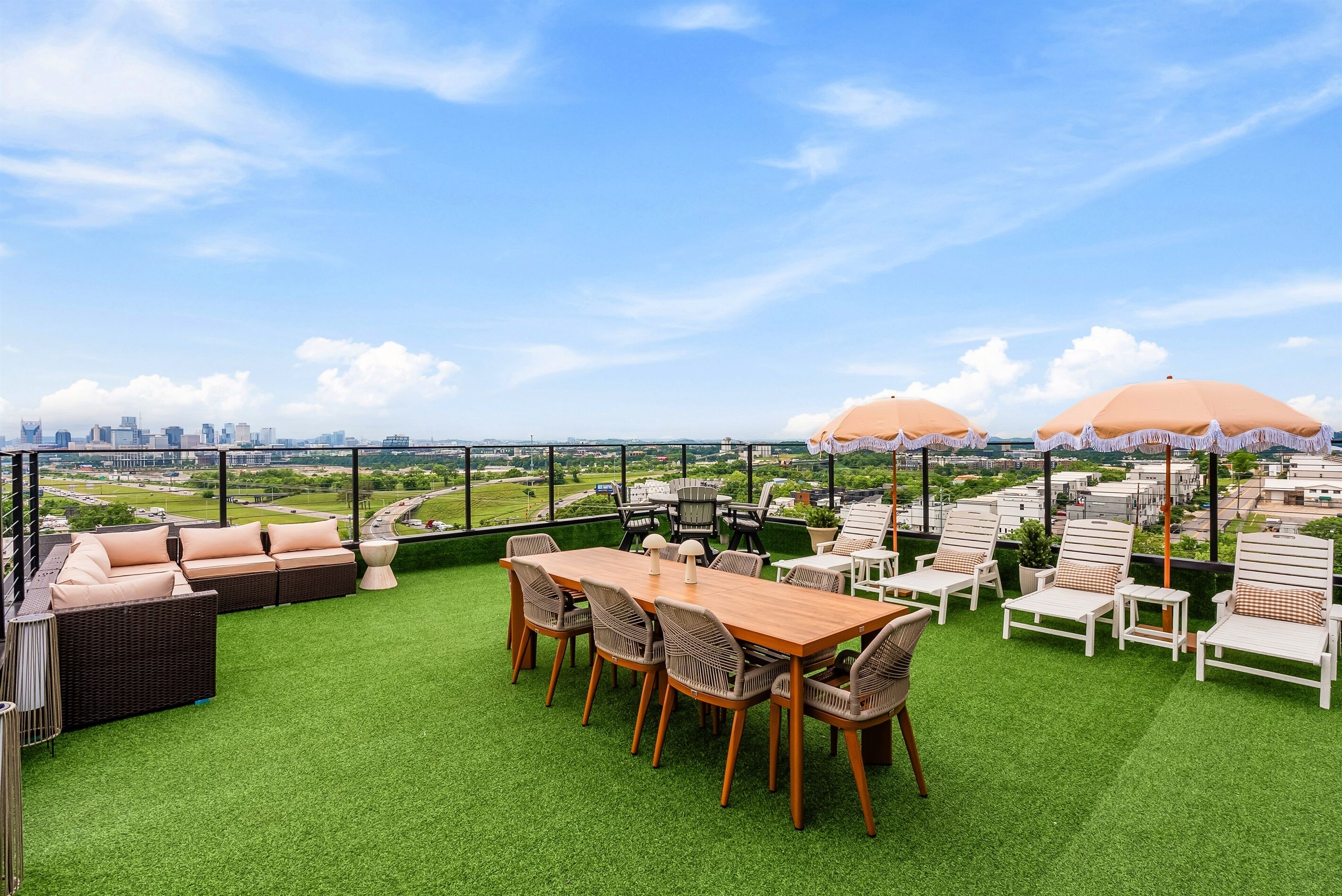 Una terraza en la azotea con mesa, sillas y zonas de estar.