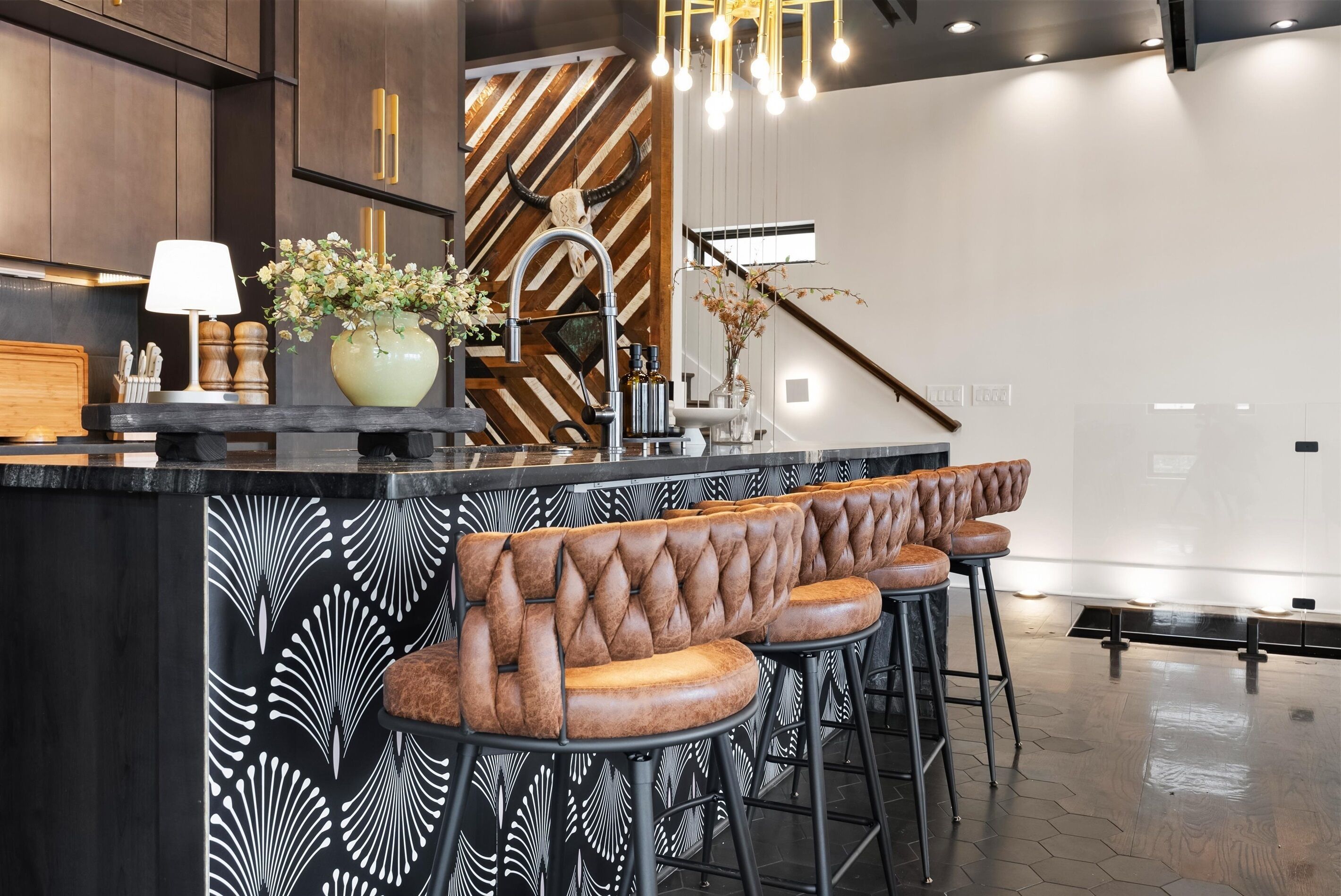 Una cocina moderna con barra, taburetes capitonados y un elegante salpicadero decorativo.