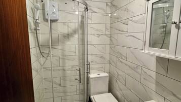A bathroom with a shower, toilet, and sink.