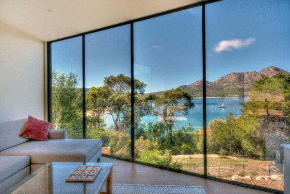 A room with a large window, a sofa, and a coffee table. - Furneaux - Complete Waterfront (Glamorgan-Spring Bay)