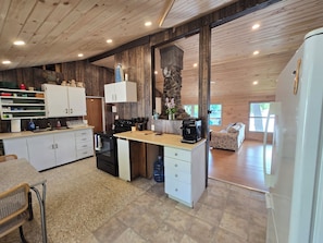 A modern kitchen with wooden accents, a coffee machine, and a stone accent wall.