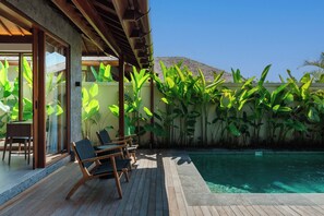 A pool area with wooden deck, lounge chairs, and tropical plants. - Apura Panoramic Villa 2BD Ubud (Ubud)