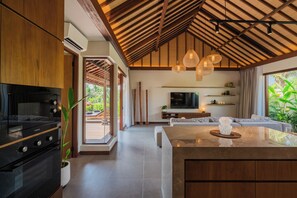 Uma cozinha moderna com uma ilha grande, eletrodomésticos embutidos e um espaço de refeições com sofá.