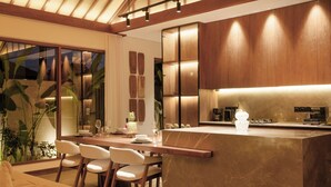A modern kitchen with a central island, wooden cabinets, and a dining area with chairs. - Apura Panoramic Villa 2BD Ubud (Ubud)