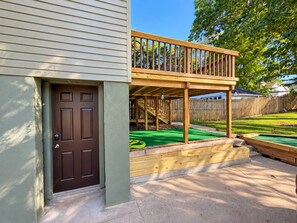 A residential deck with a wooden railing, a door, and a green artificial turf area. - 1917 Bristol Tudor, Sleeps 10, Minutes to Downtown, BMS Speedway & Holston River (Bristol)