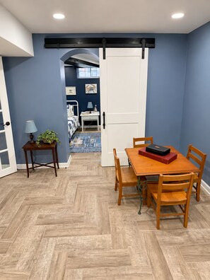 A dining area with a wooden table and chairs, a lamp, and a potted plant. - 1917 Bristol Tudor, Sleeps 10, Minutes to Downtown, BMS Speedway & Holston River (Bristol)