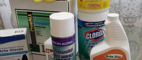 A collection of medical supplies including gloves, disinfectant wipes, and a spray bottle.