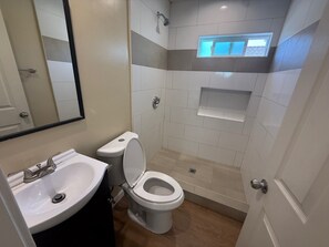 Ein Badezimmer mit Waschbecken, Toilette und Dusche.