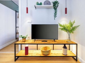 A modern living room with a flat-screen TV, wooden coffee table, and potted plants. - Cozy 2 Bedroom Apartment At Monnas Suite (Beyoglu)