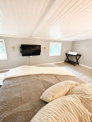 Ein Schlafzimmer mit einem Bett, einem Flachbildfernseher, einem Fenster mit Blick und einem kleinen Tisch mit Handtüchern.