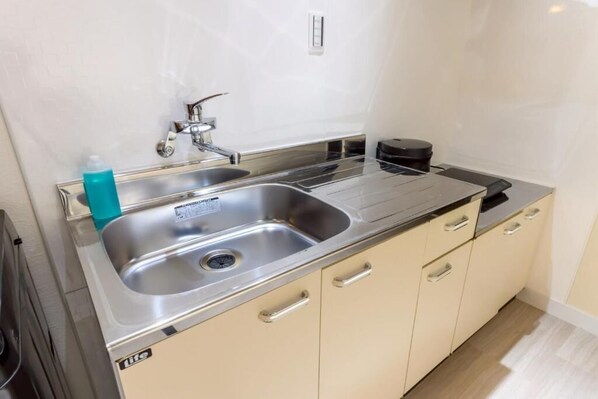 Cozinha moderna com eletrodomésticos de aço inoxidável, uma pia dupla e armários bege.