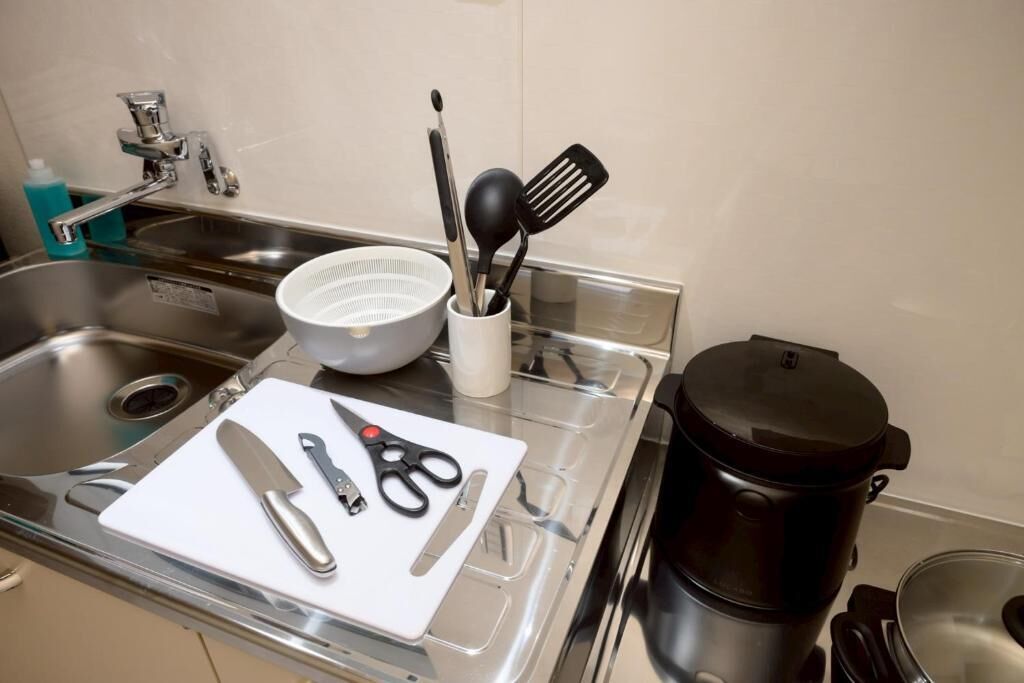 A kitchen counter with a coffee maker, a cutting board, and kitchen utensils.