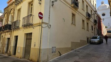 Una stretta via fiancheggiata da edifici, con un segnale di divieto di accesso e un'auto parcheggiata sul lato.