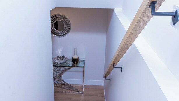 A modern staircase with wooden steps and a glass table with decorative items. - Honeycomb Suite, 2 minutes to MillCreek nature park (Riverview)