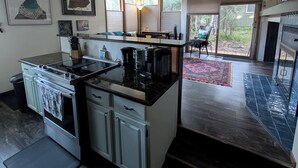 Una cocina moderna con una isla central, horno integrado y un comedor con vistas.