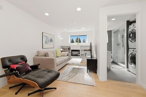 A modern living room with a leather chair, a sofa, a coffee table, and a rug. - 3BR Dunbar Family Retreat Near UBC/Transit (Vancouver)