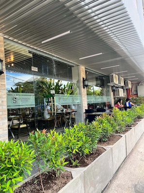 Ein modernes Restaurant mit Außenbereich, einer überdachten Terrasse und freiem Blick ins Innere.