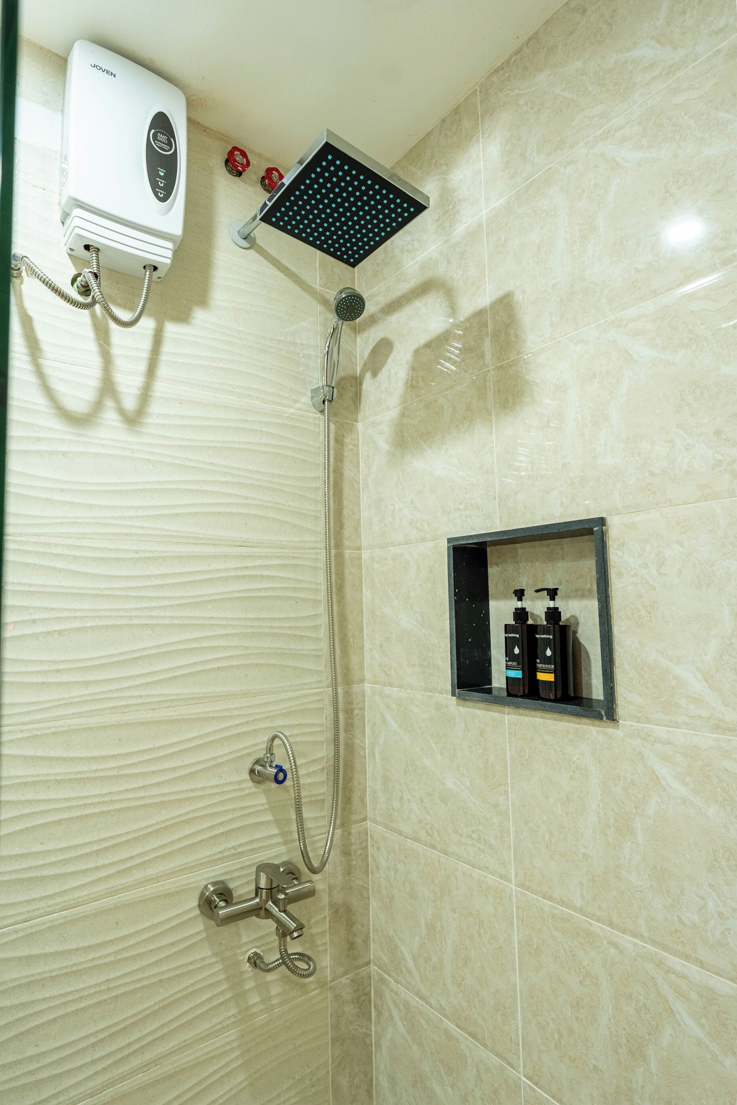 Een badkamer met een douche, een handdroger en een zeepdispenser.