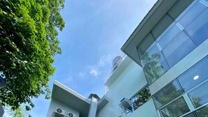 A multi-story building with a central staircase, large windows, and a modern architectural design.