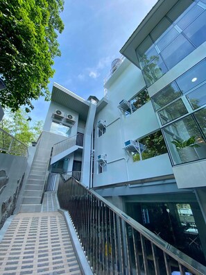 Un edificio de varios pisos con una escalera central, ventanas amplias y un diseño arquitectónico moderno.