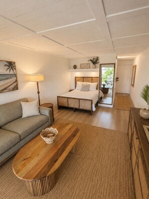 Ein Schlafzimmer mit Bett, Nachttisch, Lampe und Blick ins Freie.