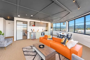 Un salon moderne avec un canapé, une table basse et une vue sur la cuisine et la salle à manger.