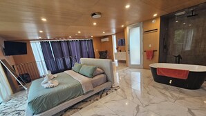 A modern hotel room with a large bed, a bathroom with a bathtub, and a view of the outdoors. - Enjoy Your Own Private Pool and Backyard Oasis in Windsor (Windsor)