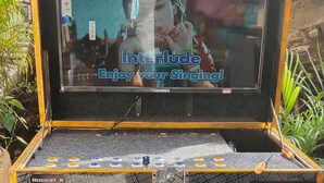 Eine Karaoke-Anlage mit Bildschirm, der einen Sänger und den Text 'Interlude Enjoy your Singing!' zeigt.