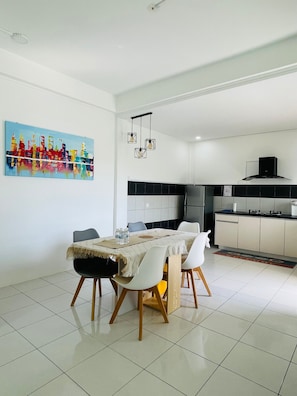 A modern kitchen with a black backsplash, white cabinets, and a stainless steel range hood.