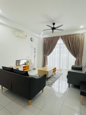 A modern living room with a sofa, a coffee table, a TV, and a ceiling fan.. Oak & Ivory Home | 3BR Ground Floor Apartment