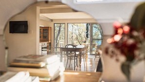 Une pièce dotée d’une grande fenêtre, d’une table à manger et d’un téléviseur.