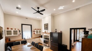 Una cucina moderna con zona pranzo, pavimento in legno e ventilatore a soffitto.