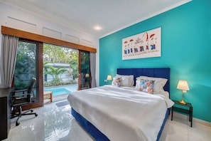 Ein Schlafzimmer mit einem großen Bett, einem Schreibtisch und Blick auf einen Swimmingpool.