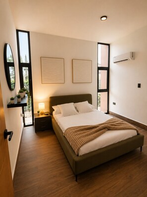 Ein modernes Schlafzimmer mit einem großen Bett, Nachttischen, einem Spiegel und Kunstwerken an den Wänden.