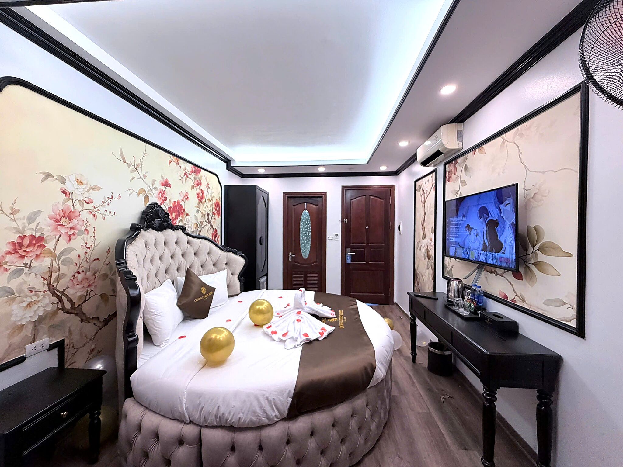 Una habitación de hotel con una cama grande, televisión y escritorio.